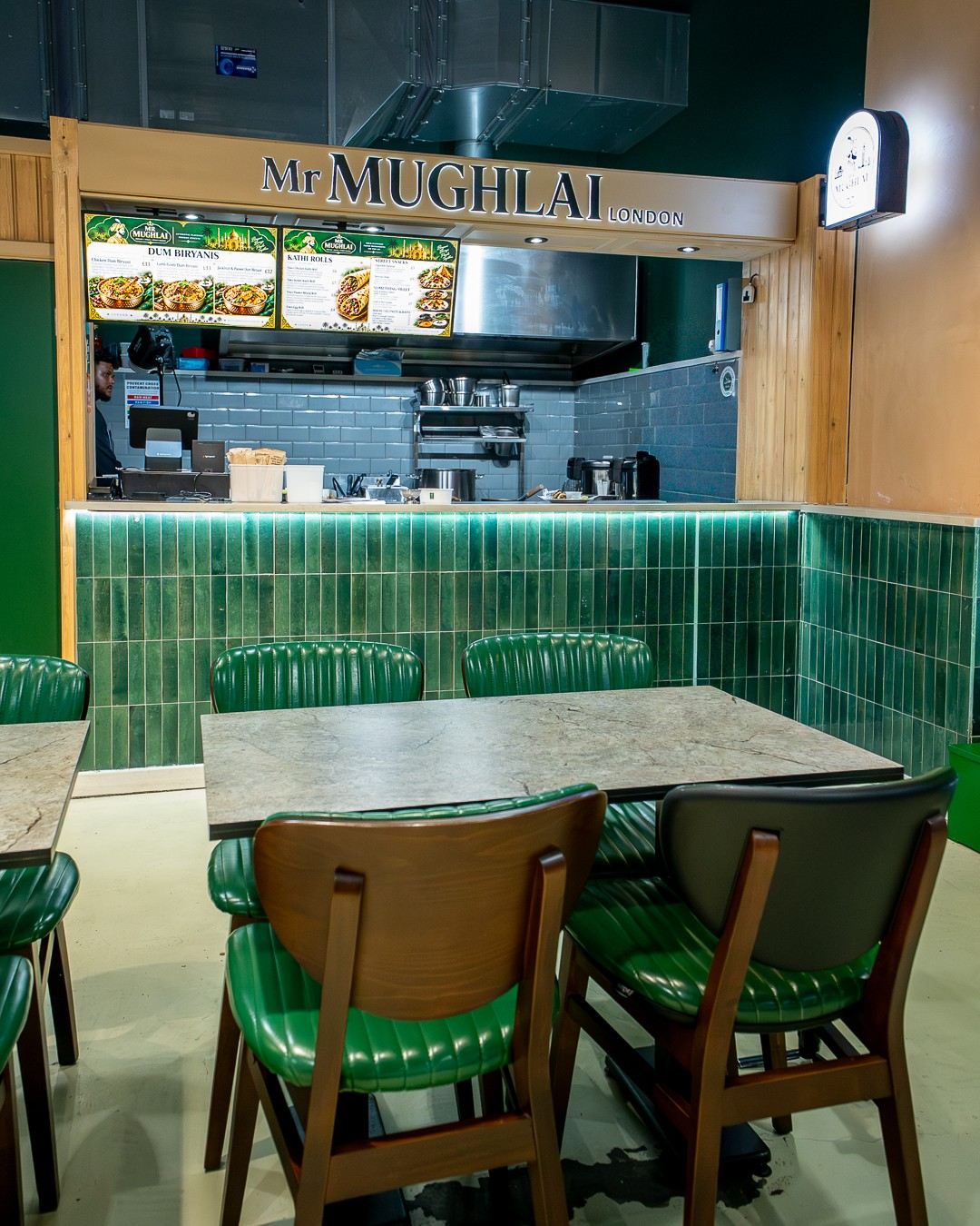 Dining area with green seating at Mr Mughlai London